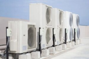Row of large outdoor air conditioner units on a rooftop